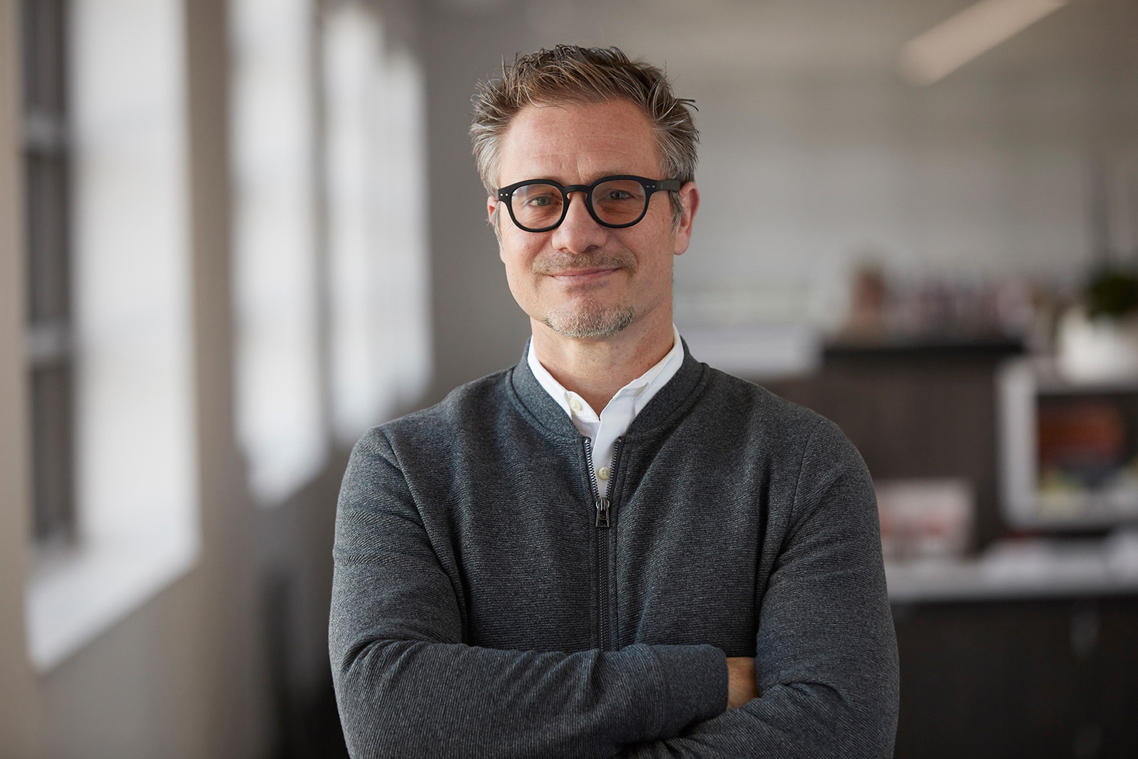 Professional man wearing glasses with folded arms